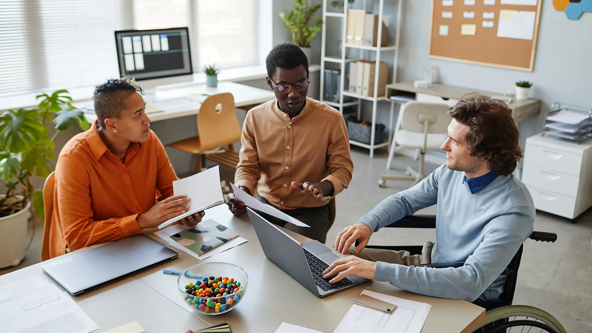 Gruppe von Männern sitzen um einen Tisch und besprechen ein Websiteprojekt.